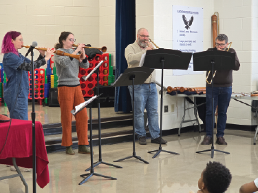 four musicians playing win instruments